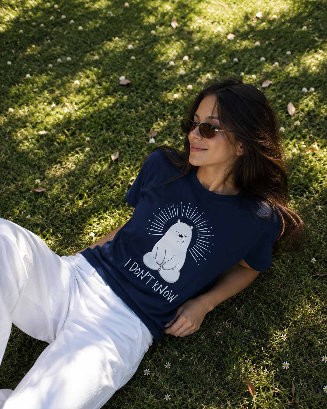 Woman lying on grass wearing the navy I don't know graphic tee